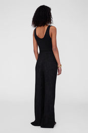 Black wide-leg pants with a textured finish, worn with a black sleeveless top, viewed from the back.