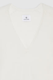 Ivory sweater with a V-neckline and a tag displaying the brand name "ANINE BING."
