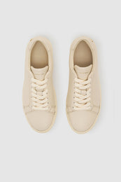 Beige pebbled leather sneakers with round toe and lace-up closure.