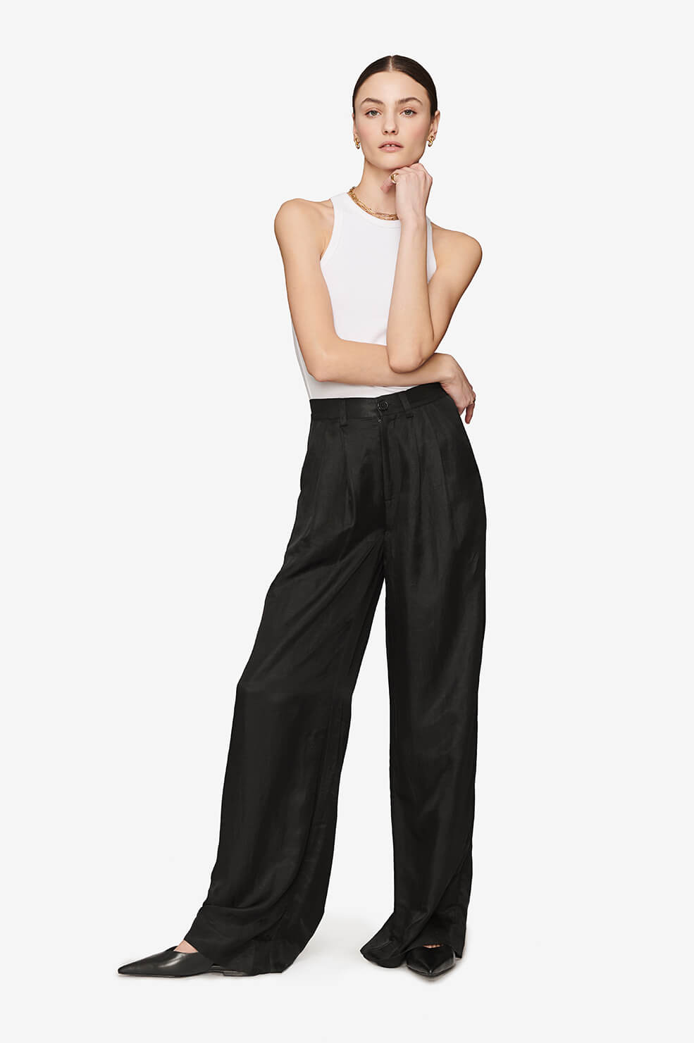 Wide-leg black pants paired with a white sleeveless top and black pointed-toe shoes.